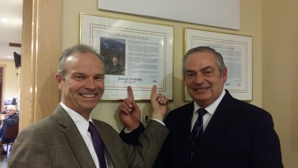 ORDA CEO Ted Blazer and ROOST CEO James McKenna point out their logos on McKenna's Hall of Fame plaque.