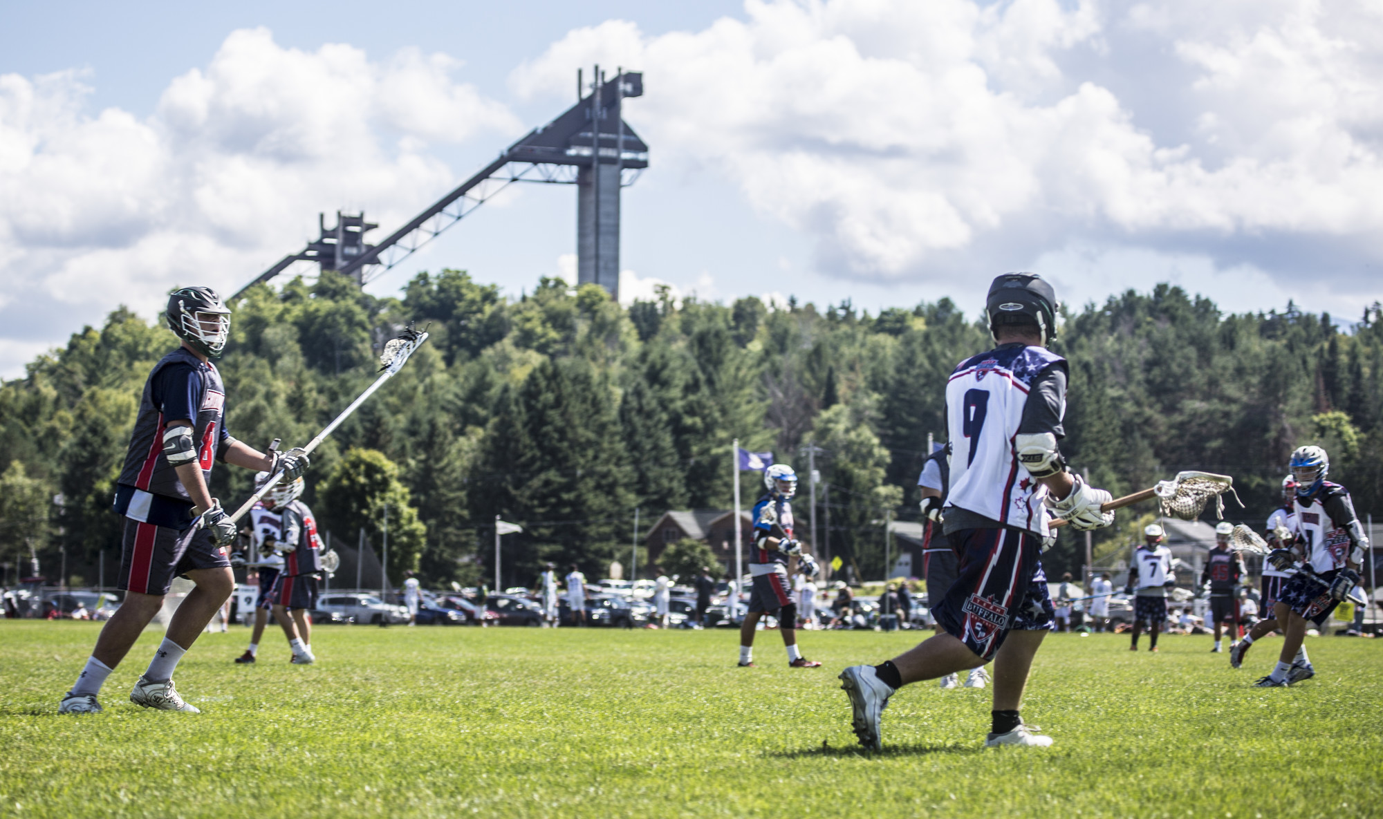 Athletes compete in the Lake Placid Lacrosse Tournament with views of the ski jumps behind them.