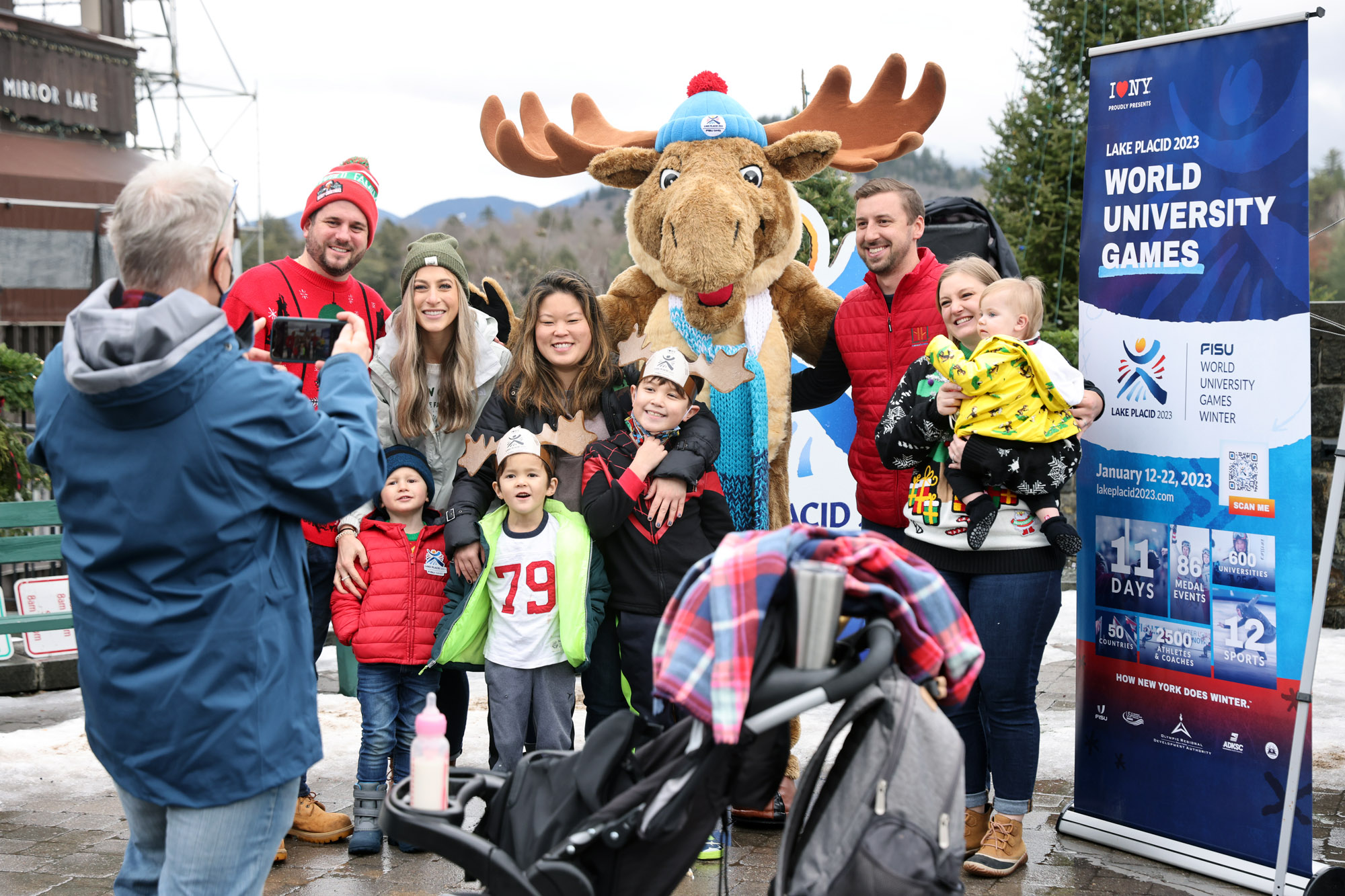 People pose with Mac the World University Games Mascot